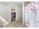 Bathroom entrance with wood-look flooring, patterned wallpaper, and a view into walk-in closet at 20181 N Lauren Rd, Maricopa, AZ 85138