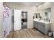 Bright bathroom with double vanity, wood-look flooring, and an open doorway to bedroom at 20181 N Lauren Rd, Maricopa, AZ 85138