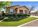 Well maintained single story home with desert landscaping, artificial turf, and stone accents on the facade at 20181 N Lauren Rd, Maricopa, AZ 85138