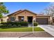 Charming single-story home featuring a well-manicured lawn, stone accents, and an attached two-car garage at 20181 N Lauren Rd, Maricopa, AZ 85138