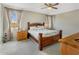 Comfortable bedroom with floral bedding, ceiling fan, and bright windows with patterned curtains at 20181 N Lauren Rd, Maricopa, AZ 85138