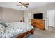 Main bedroom featuring a ceiling fan, decorative accents, a TV, and ensuite bathroom access at 20181 N Lauren Rd, Maricopa, AZ 85138
