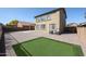 Large backyard features pavers, a putting green, block fence, and mature landscaping for outdoor privacy at 21549 N Backus Dr, Maricopa, AZ 85138