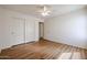 Clean bedroom with hardwood floors, closet, neutral paint, and ceiling fan for a calm setting at 21549 N Backus Dr, Maricopa, AZ 85138