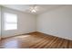 Bright bedroom featuring laminate floors, a ceiling fan, and large window letting in plenty of natural light at 21549 N Backus Dr, Maricopa, AZ 85138