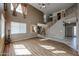 Open concept living room features wood floors, high ceilings, and staircase access to upper floor at 21549 N Backus Dr, Maricopa, AZ 85138