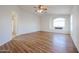 Large main bedroom features wood-look flooring, ceiling fan and bright window at 21549 N Backus Dr, Maricopa, AZ 85138