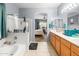 Inviting bathroom with tiled floor, shower, tub, and vanity with wood cabinets, flowing into the bedroom at 21963 W Tonto St, Buckeye, AZ 85326