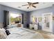 Bedroom with ample natural light featuring a ceiling fan, adjacent desk, and a door to the patio at 21963 W Tonto St, Buckeye, AZ 85326