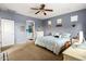 Comfortable bedroom with blue accent wall and plush carpeting, flowing through to a tranquil bathroom at 21963 W Tonto St, Buckeye, AZ 85326
