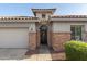 Close-up of a home's front entrance, featuring a decorative door, stone accents, and manicured landscaping at 21963 W Tonto St, Buckeye, AZ 85326