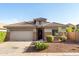 Charming single-story home featuring a tile roof, stone accents, desert landscaping, and a two-car garage at 21963 W Tonto St, Buckeye, AZ 85326