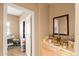 Entryway with a light wood console table, decorated mirror, candles and decorative items with a room in the background at 21963 W Tonto St, Buckeye, AZ 85326
