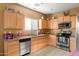 Well-lit kitchen with stainless steel appliances, wooden cabinets, and stone countertops at 21963 W Tonto St, Buckeye, AZ 85326