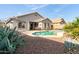 Backyard oasis featuring a private pool, covered patio, and desert landscaping, perfect for relaxation at 21963 W Tonto St, Buckeye, AZ 85326