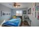 A room with a comfortable bed, colorful posters, and a ceiling fan at 22741 N Scott Dr, Maricopa, AZ 85138