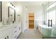 Stylish bathroom showcasing double vanity, sleek mirror, soaking tub, and glass-enclosed shower; closet visible at 23046 N 88Th Way, Scottsdale, AZ 85255