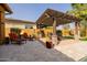Outdoor living area featuring a travertine patio with a pergola, lounge seating, and a gas fire pit, great for relaxation at 2361 N 156Th Dr, Goodyear, AZ 85395
