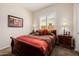 Comfortable bedroom with plush bedding, wooden furnishings, bedside tables, and a sunlit window at 2361 N 156Th Dr, Goodyear, AZ 85395