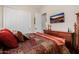 Inviting bedroom with a decorative bedspread, wood dresser, and wall-mounted TV at 2361 N 156Th Dr, Goodyear, AZ 85395