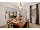 Elegant dining area with wood table, decorative place settings, and a view into the adjacent living space at 2361 N 156Th Dr, Goodyear, AZ 85395