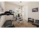 Brightly lit home exercise room with a treadmill, weight machine, and free weights for a complete workout at 2361 N 156Th Dr, Goodyear, AZ 85395