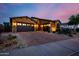 Beautiful stucco home with stone accents, large driveway, and three-car garage at dusk at 2361 N 156Th Dr, Goodyear, AZ 85395