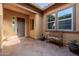 Covered front porch has tile floor, bench and lush plants at 2361 N 156Th Dr, Goodyear, AZ 85395