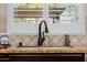 Close-up of kitchen sink with modern faucet fixture and matching backsplash at 2361 N 156Th Dr, Goodyear, AZ 85395