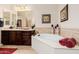 Serene main bathroom featuring a large tub, dark wood vanity, and decorative accents at 2361 N 156Th Dr, Goodyear, AZ 85395