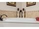 Tranquil main bathroom showcasing a deep soaking tub with decorative candles and tiled accents at 2361 N 156Th Dr, Goodyear, AZ 85395