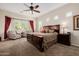 Spacious main bedroom featuring a large bed, ceiling fan, and bright natural light from the windows at 2361 N 156Th Dr, Goodyear, AZ 85395