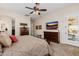 Well-lit main bedroom featuring a ceiling fan, TV, dressers, and access to an outdoor patio at 2361 N 156Th Dr, Goodyear, AZ 85395