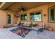 Inviting covered patio with comfortable seating, ceiling fan, and mounted television for relaxing outdoors at 2361 N 156Th Dr, Goodyear, AZ 85395