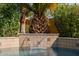 A pristine pool with a stacked tile waterfall feature and mature landscaping at 2361 N 156Th Dr, Goodyear, AZ 85395