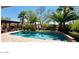 Sparkling pool surrounded by lush landscaping and a covered patio, perfect for outdoor relaxation at 2361 N 156Th Dr, Goodyear, AZ 85395