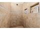 Tiled walk-in shower with built-in shelving and decorative accents at 2361 N 156Th Dr, Goodyear, AZ 85395
