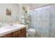 Cozy bathroom has a classic sink, tile countertops, and a decorative shower curtain over the shower at 241 W Atlantic Dr, Casa Grande, AZ 85122