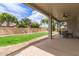 A covered backyard patio with ceiling fan overlooks lush landscaping and privacy wall at 2600 E Hazeltine Way, Chandler, AZ 85249