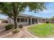 A backyard with covered patio overlooks lush green lawn and desert landscaping at 2600 E Hazeltine Way, Chandler, AZ 85249
