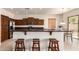 Stylish kitchen featuring dark wood cabinetry, stainless steel appliances, and a breakfast bar with seating at 2600 E Hazeltine Way, Chandler, AZ 85249