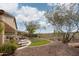 Relaxing backyard includes a desert view, lush green artificial grass, and various seating options at 27196 N 129Th Dr, Peoria, AZ 85383