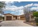 Stylish home exterior with a circular driveway, desert landscaping, and a three-car garage at 27196 N 129Th Dr, Peoria, AZ 85383