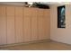 Garage with built in storage cabinets and a window at 27196 N 129Th Dr, Peoria, AZ 85383