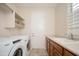 Functional laundry room with a front loading washer/dryer, a sink, and ample counter space at 27196 N 129Th Dr, Peoria, AZ 85383