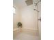 Bright shower with a rainfall shower head and handheld shower head, bench, and window at 27196 N 129Th Dr, Peoria, AZ 85383