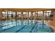 Stunning indoor swimming pool featuring clear blue water, lane markers, and expansive windows with golf course views at 27196 N 129Th Dr, Peoria, AZ 85383