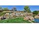 Beautiful water feature with stacked stone and lush landscaping, enhancing the community's ambiance at 27196 N 129Th Dr, Peoria, AZ 85383