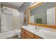 Bright bathroom features a vanity with oak cabinets, a sink, and shower/tub combination with glass doors at 2859 E Cathy Dr, Gilbert, AZ 85296