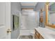 Well-lit bathroom with oak cabinetry, spacious vanity, and a shower/tub combination with glass doors for easy access at 2859 E Cathy Dr, Gilbert, AZ 85296